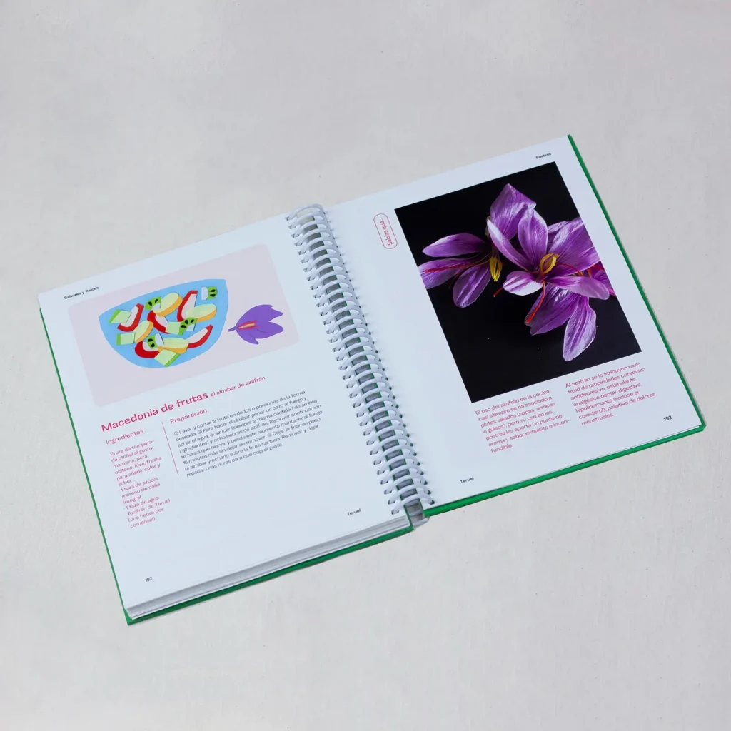 Doble página interior del libro abierta en espiral, con la receta ilustrada de "Macedonia de frutas al almíbar de azafrán" a la izquierda y una fotografía de flores de azafrán morado a la derecha.